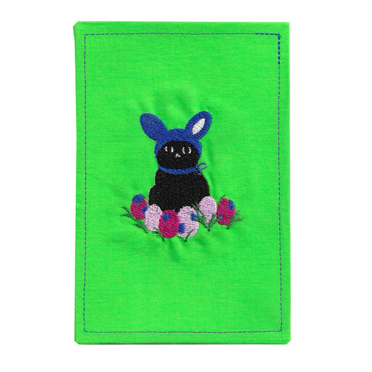 Green fabric card holder with a black cat in a blue sweater and Easter eggs design on a white background